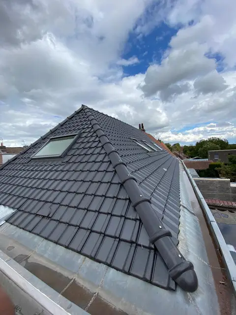 Rénovation de toiture en tuiles anthracite avec fenêtres de toit Velux et arêtier neuf, métropole lilloise