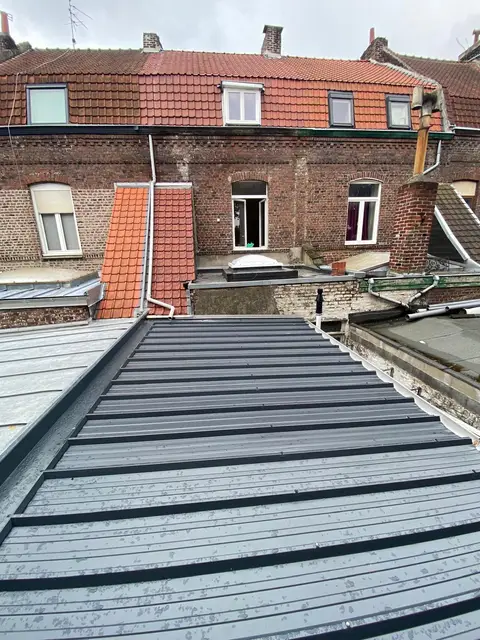 Couverture métallique anthracite neuve entre maisons de briques, métropole lilloise