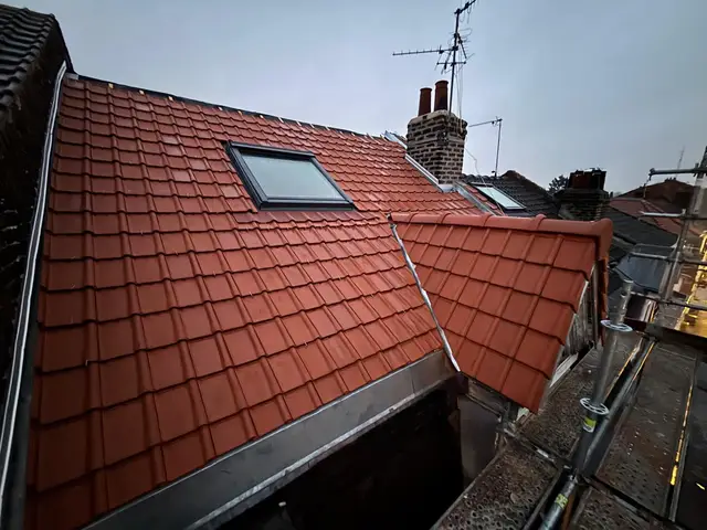 Toiture neuve en tuiles rouges avec fenêtre de toit Velux, métropole lilloise