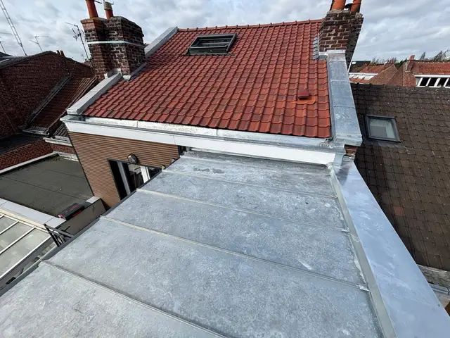Couverture en zinc à joint debout raccordée à une toiture neuve en tuiles avec fenêtre de toit, métropole lilloise