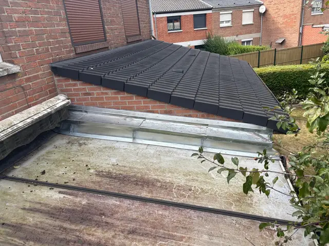 Couverture neuve en tuiles noires avec solins zinc au raccord d'un toit plat, métropole lilloise